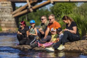 kivellä istuu kaksi perhettä