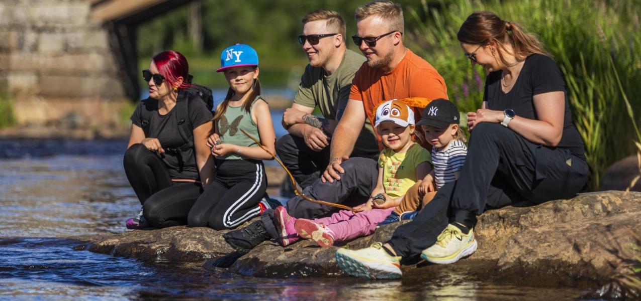 kivellä istuu kaksi perhettä