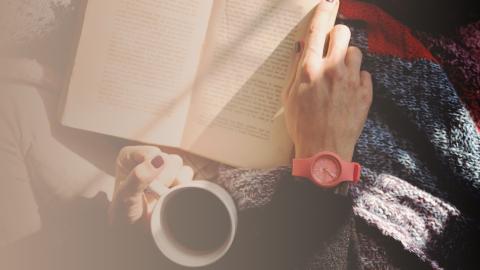 Kuvassa avoin kirja ja kahvikuppi