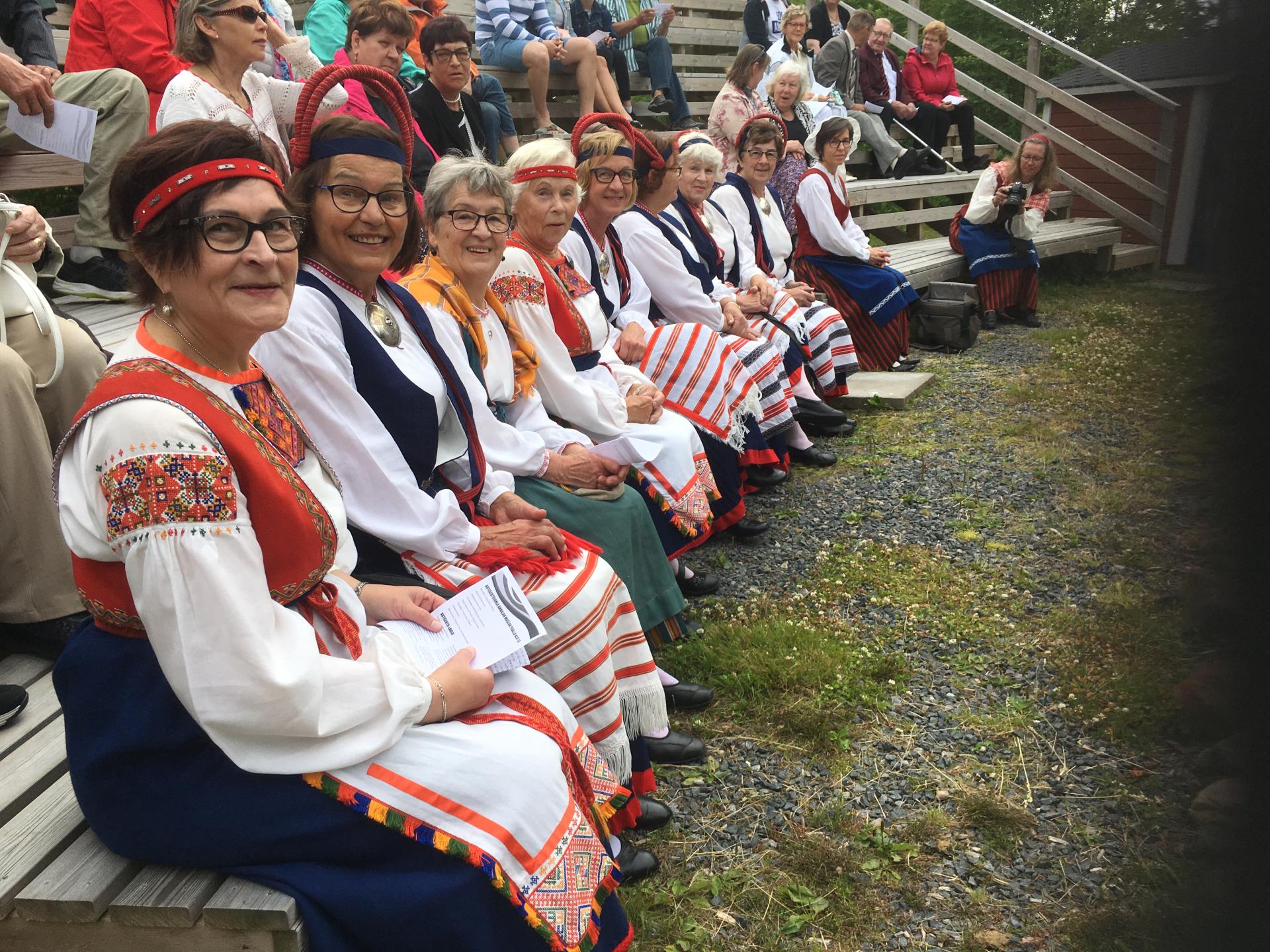 Kuvassa kansallispukuisia juhlijoita.